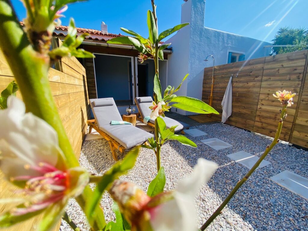 De tuin van ons vakantiehuis op Samos met buitendouche en ligbedjes, bougainvillea holiday home